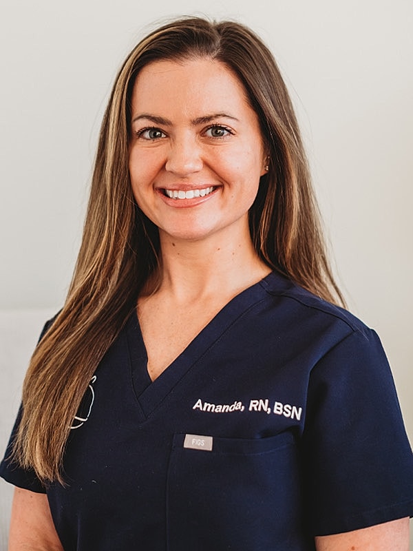 Smiling nurse wearing scrubs, professional portrait.