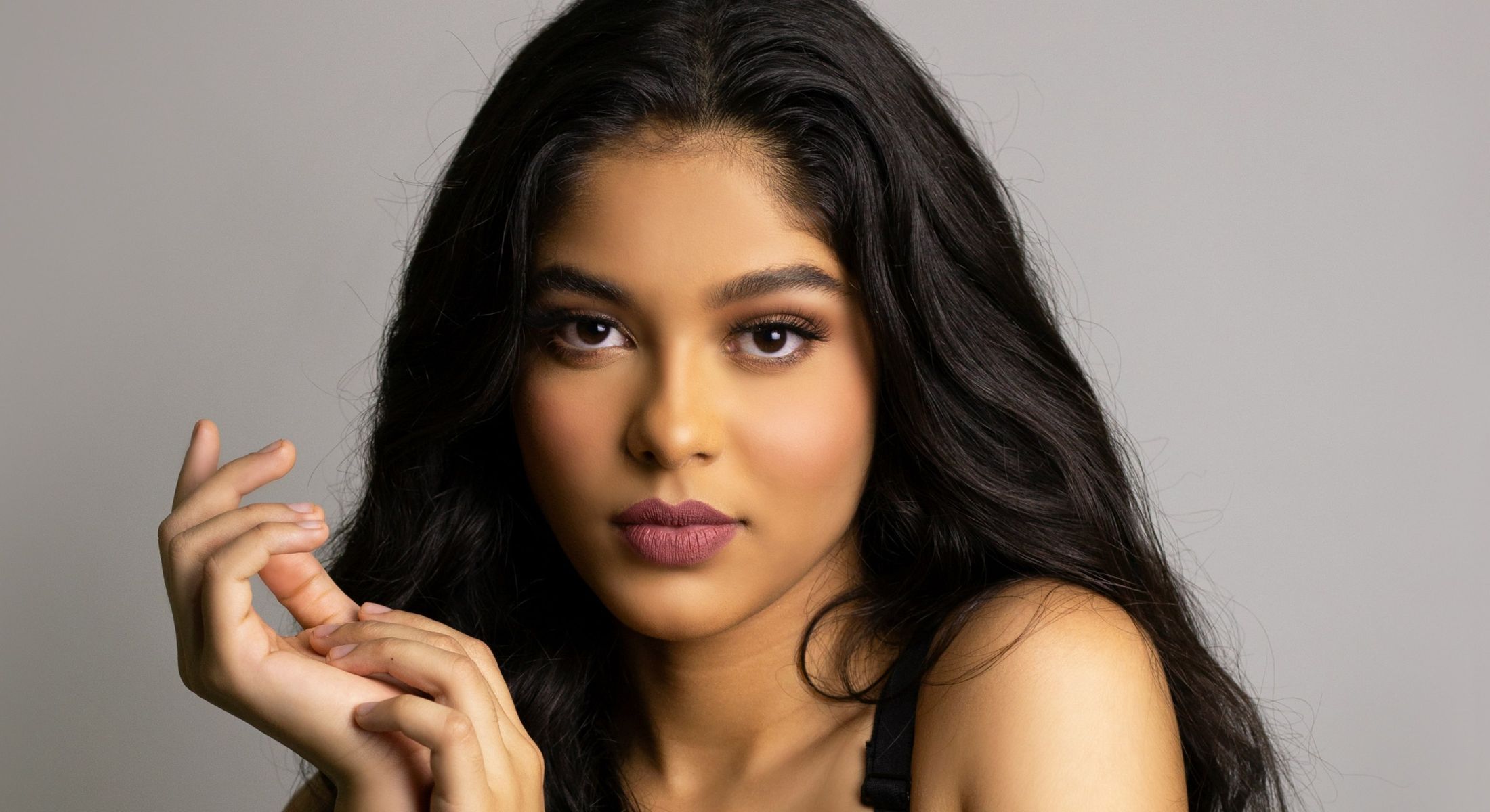 Young woman with long hair posing elegantly.